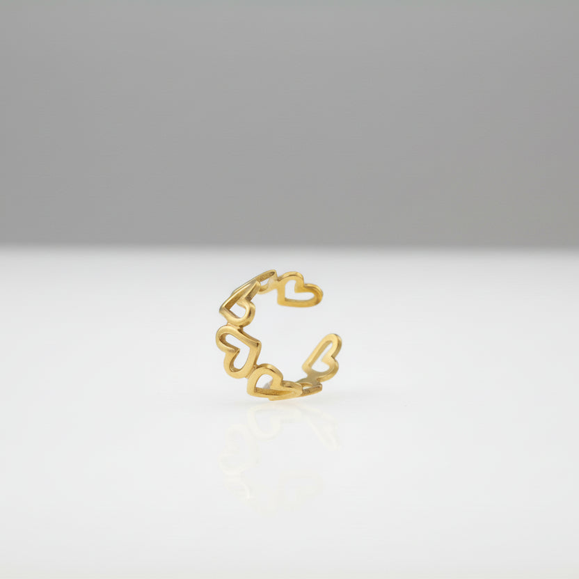 Gold hoop heart ring on a white surface