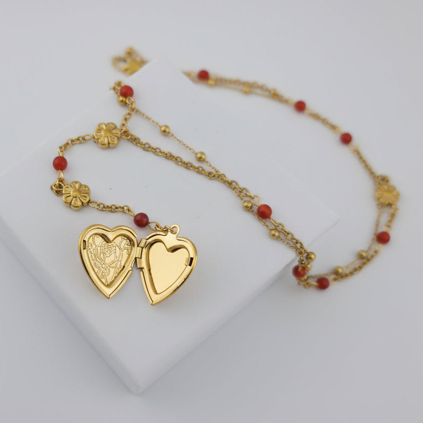 Gold necklace with heart-shaped pendants on a white box