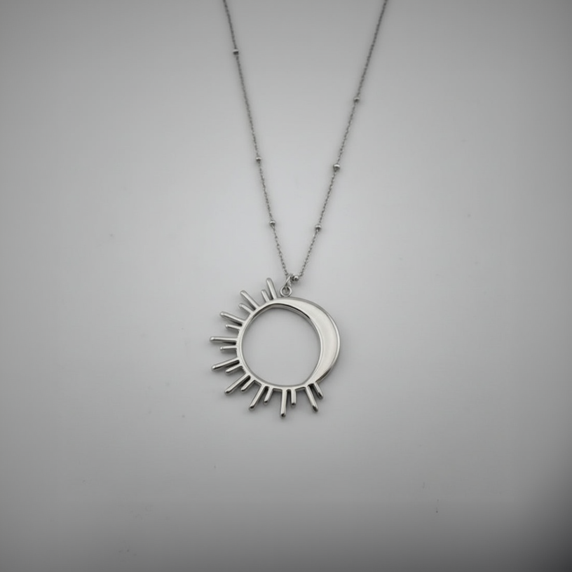 Silver necklace with a sun-shaped pendant on a gray background