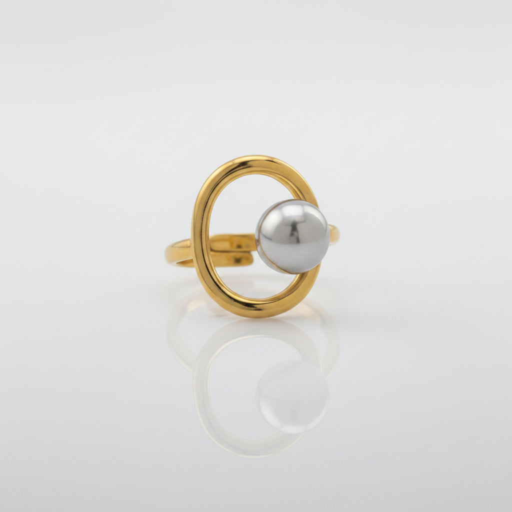 Gold ring with a silver sphere on a gray background