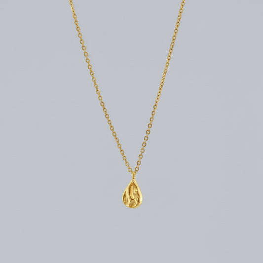 Gold teardrop pendant necklace on a light gray background