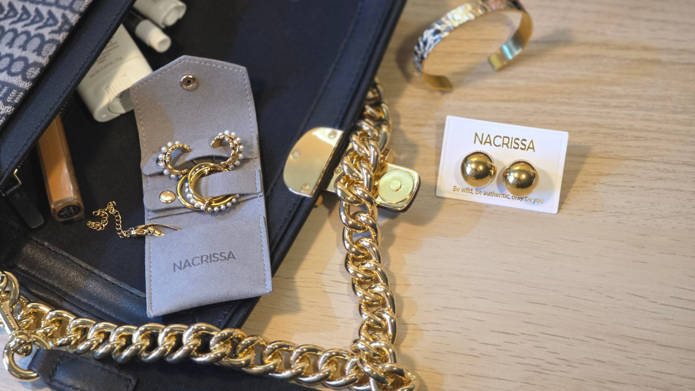 Gold jewelry including earrings and a bracelet on a wooden surface with a black box.