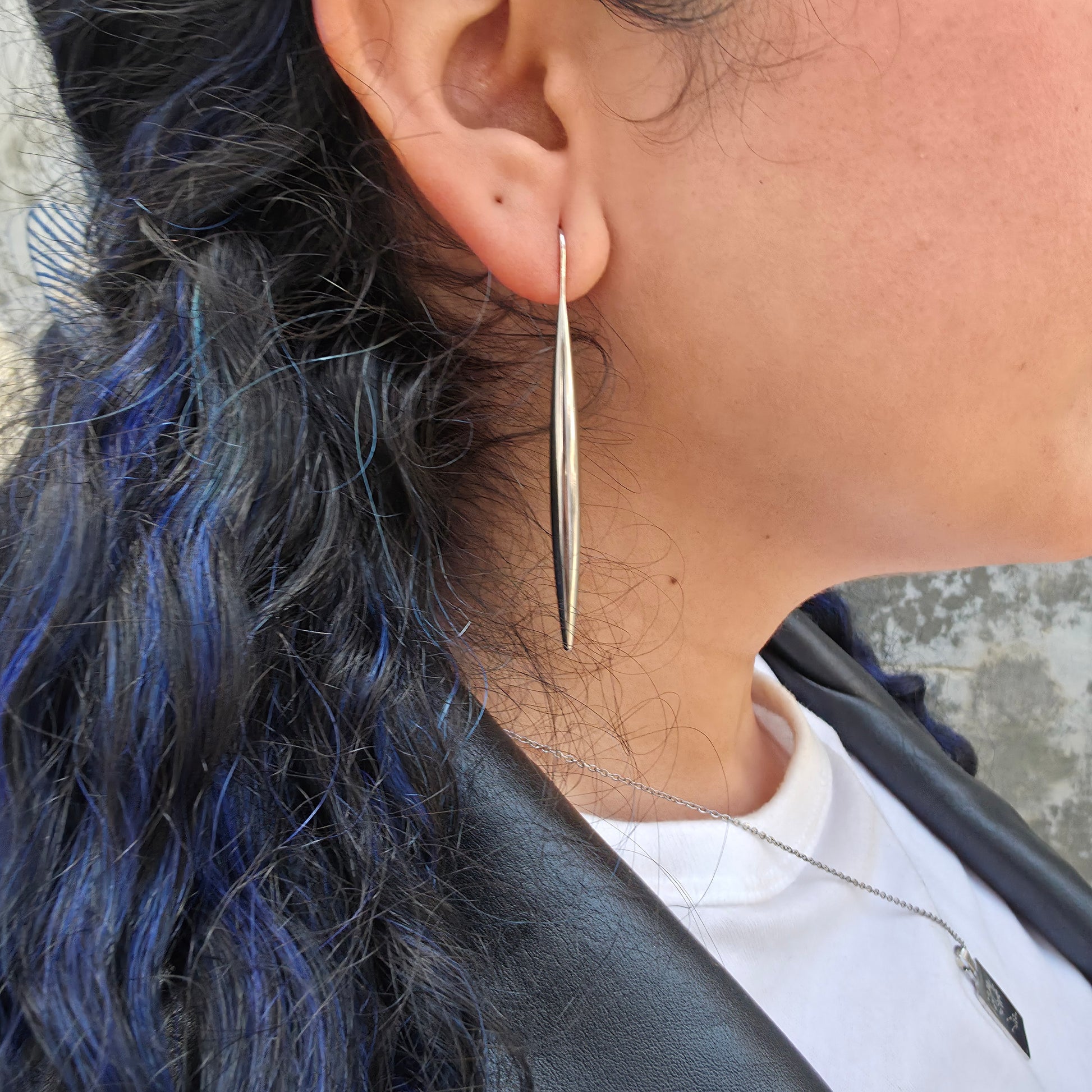 Close-up of a woman wearing the Stiletto earring.