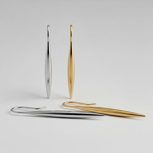 Gold and silver earrings on a light gray background