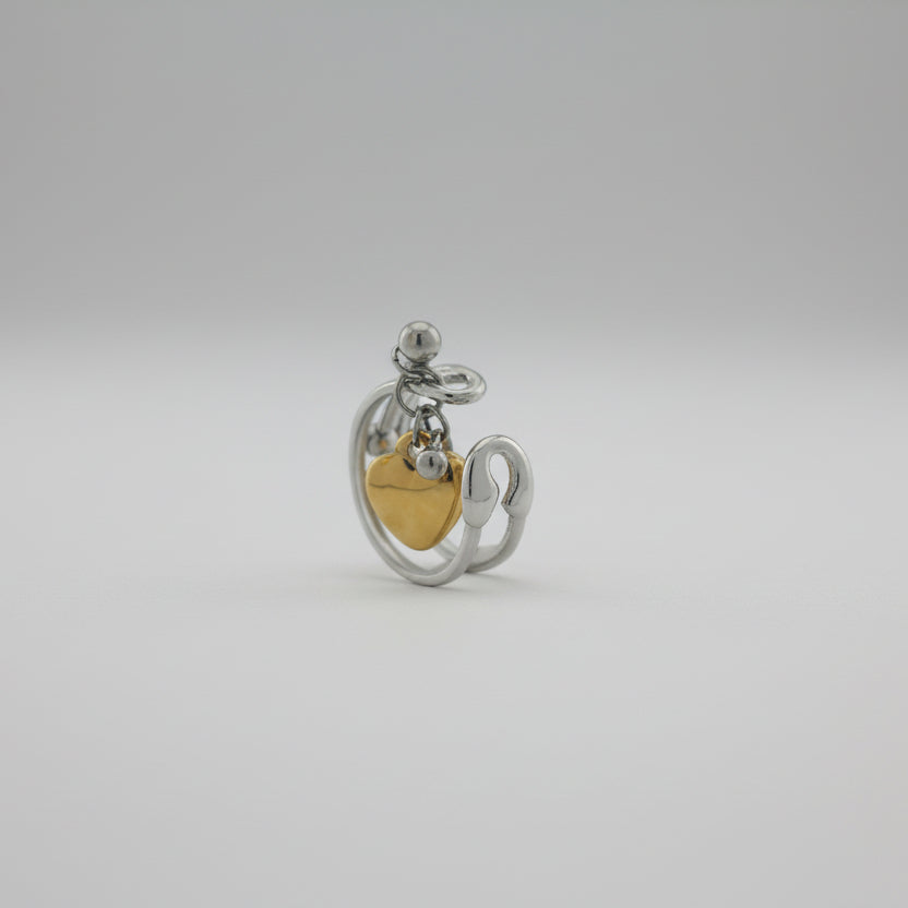 Silver and gold heart-shaped pendant on a gray background