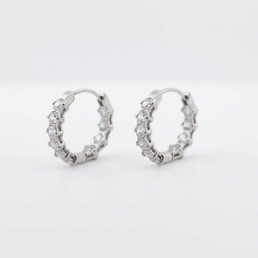 Silver ring with small stones on a light gray background