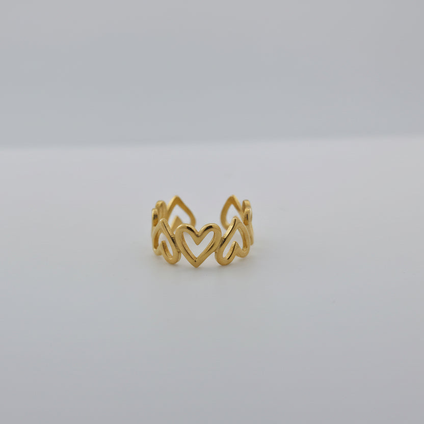 Gold ring with a wavy design on a white surface