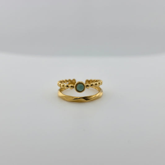 Gold ring with a green gemstone in a gray box