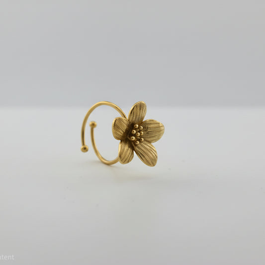 Gold flower-shaped ring on a white background