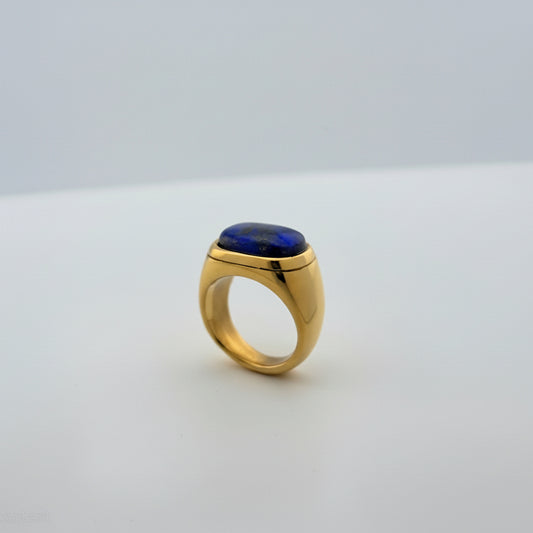 Gold ring with a blue stone on a white background