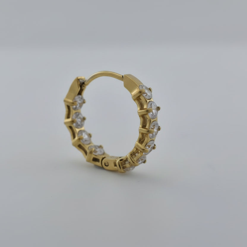 Gold earring with diamonds on a white background