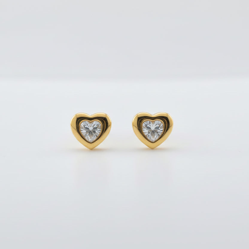 Gold heart-shaped earring with a clear gemstone on a white background