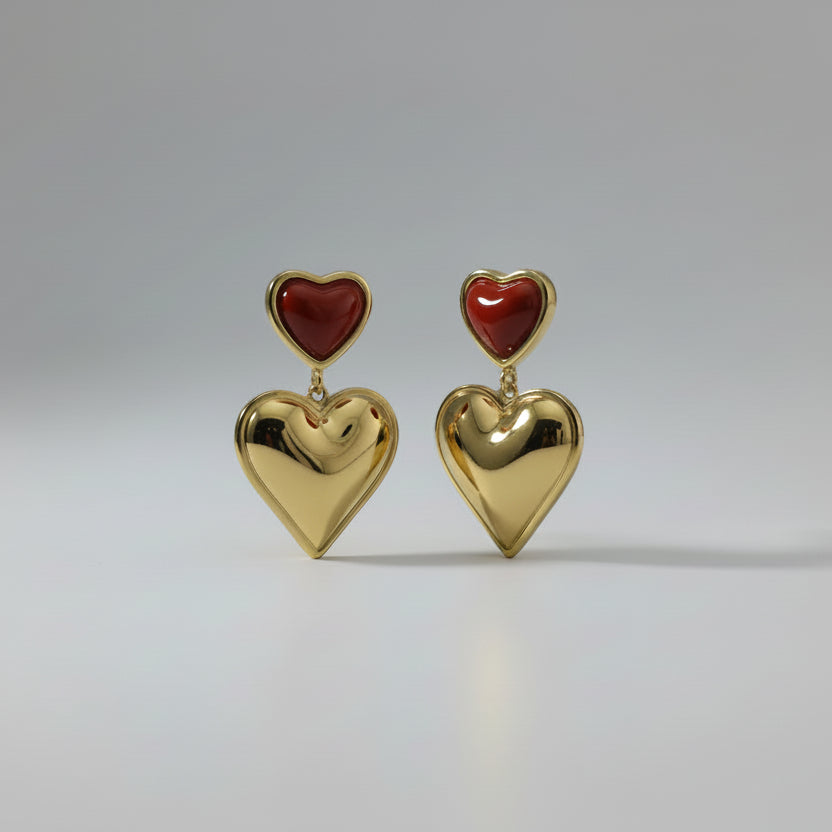 Gold earring with red heart on a white card