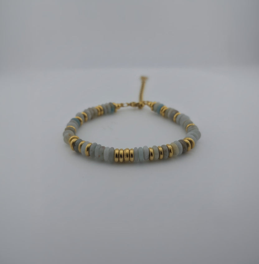 Bracelet with gray beads and gold accents on a white background