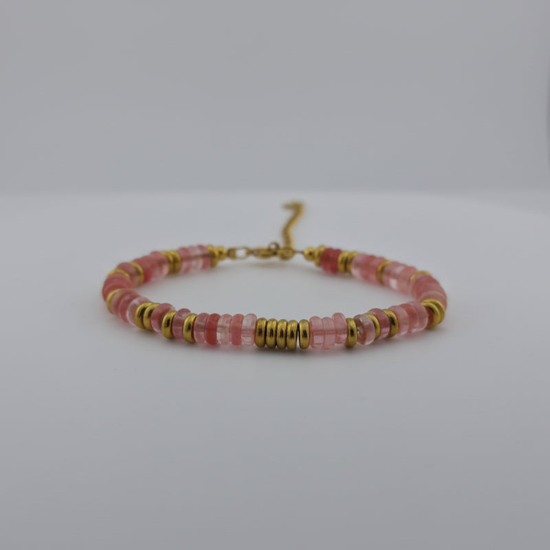 Beaded bracelet with pink and gold beads on a white background