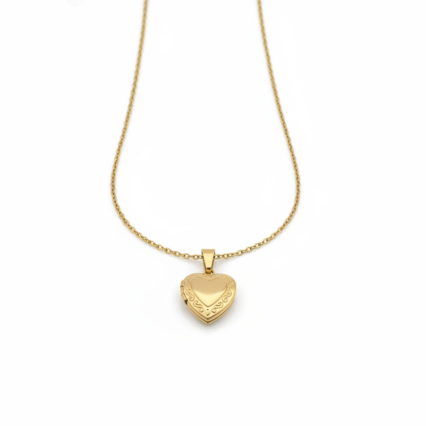 Gold necklace with a heart-shaped pendant on a gray background