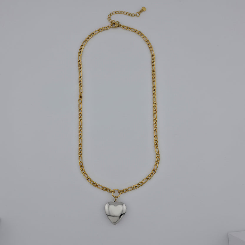 Gold chain necklace with a heart-shaped pendant on a gray background