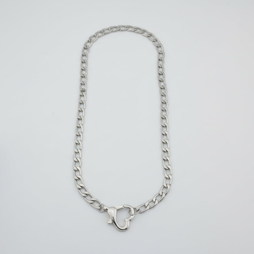 Silver chain necklace on a light gray background