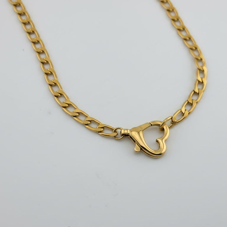 Gold chain necklace on a gray background