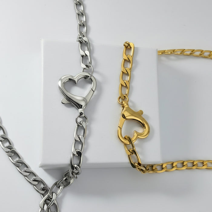 Gold and silver chain necklaces with heart-shaped clasp on a white background