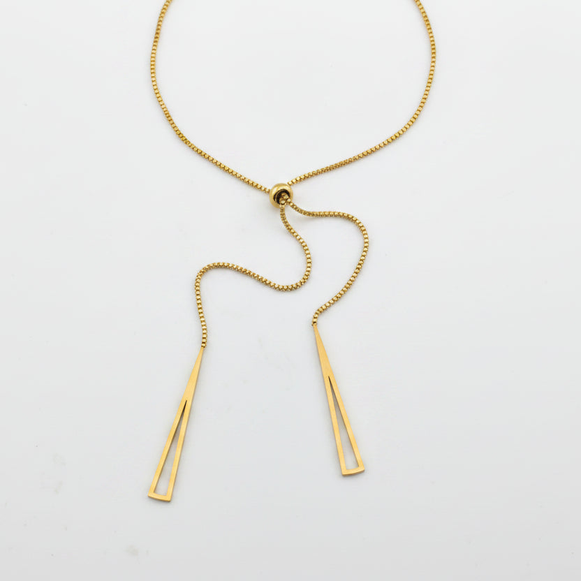 Gold necklace with two pendant bars on a light gray background