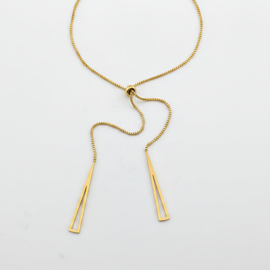 Gold necklace with two pendant bars on a light gray background