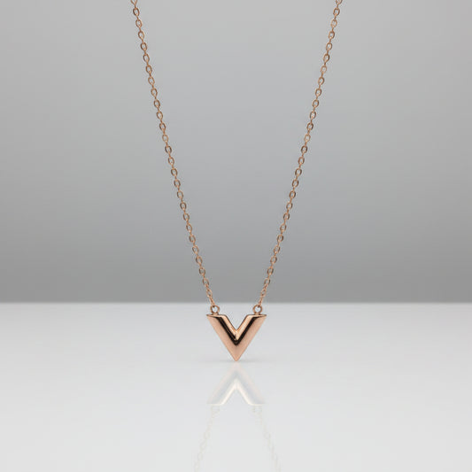 Rose gold necklace with a V-shaped pendant on a light gray background