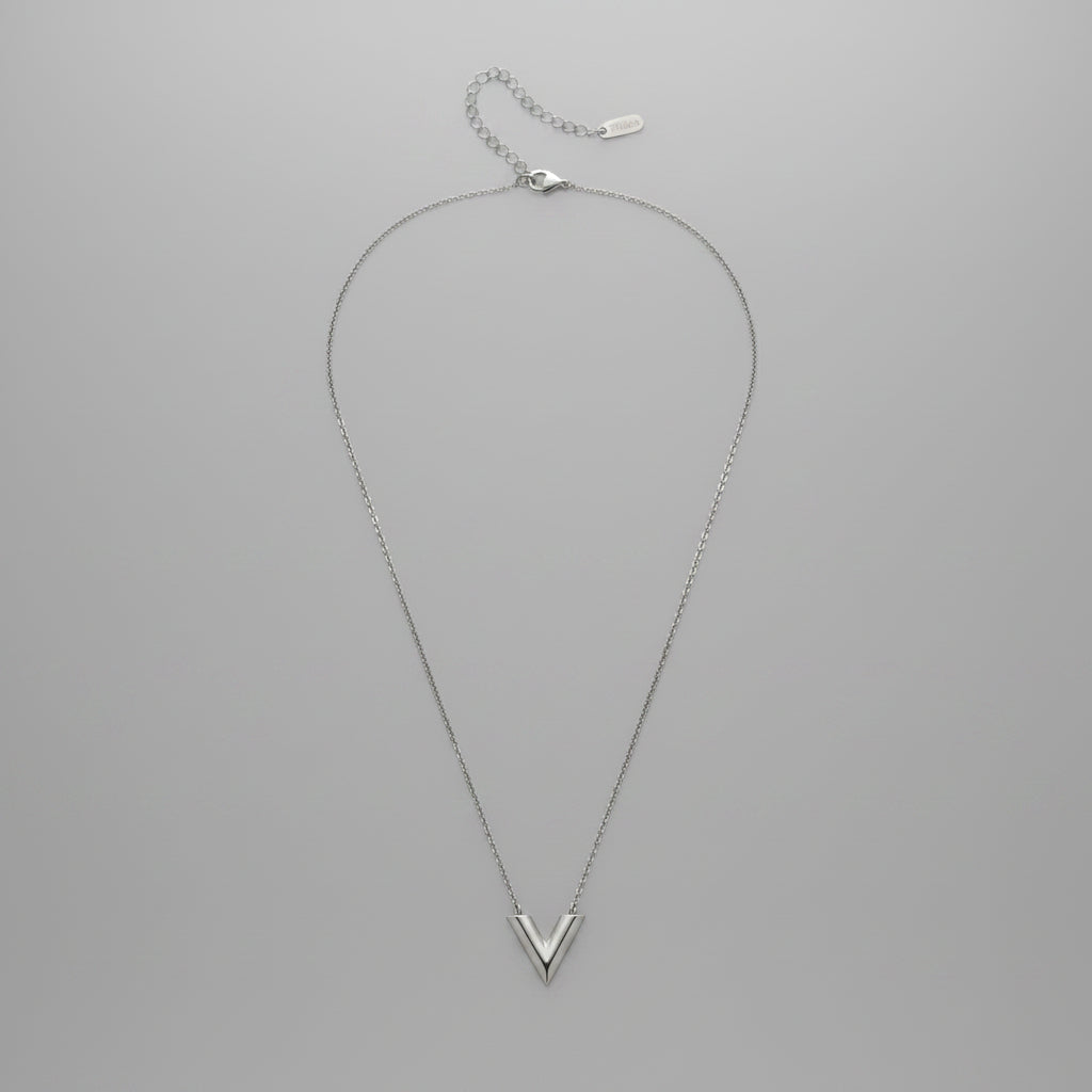 Silver necklace on a light gray background