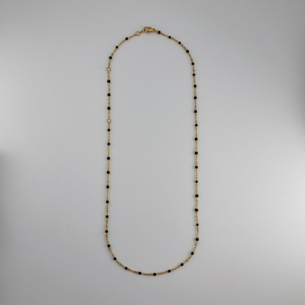 Necklace with black and gold beads on a white background