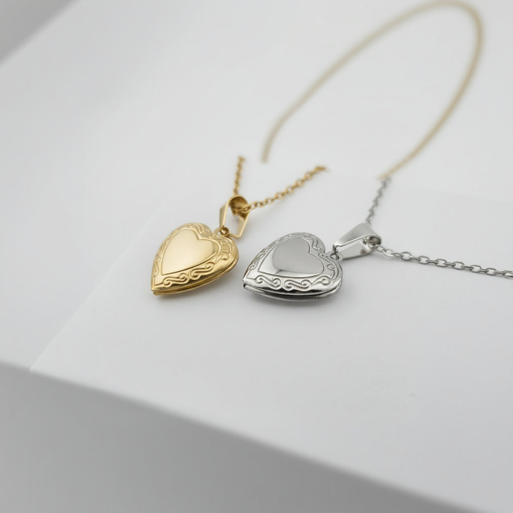 Two heart-shaped pendants on chains against a white box background