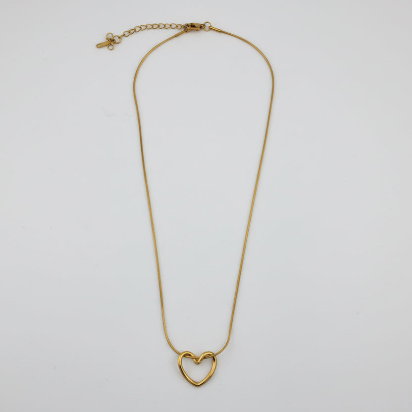 Gold heart-shaped necklace on a light gray background