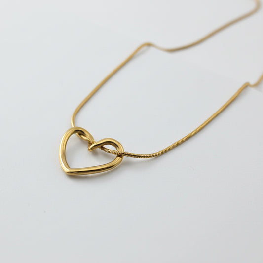Gold heart-shaped necklace on a white box