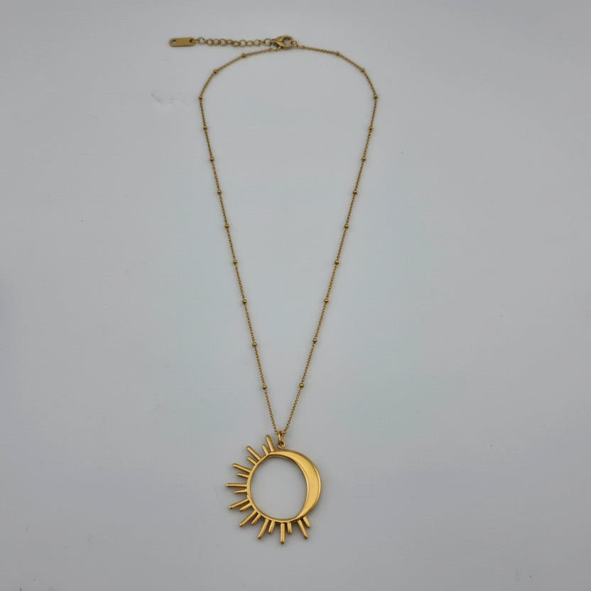 Gold necklace with a sun-shaped pendant on a white background