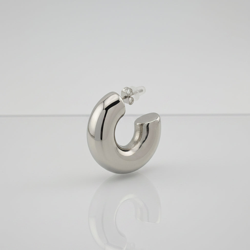 Silver hoop earring on a gray background