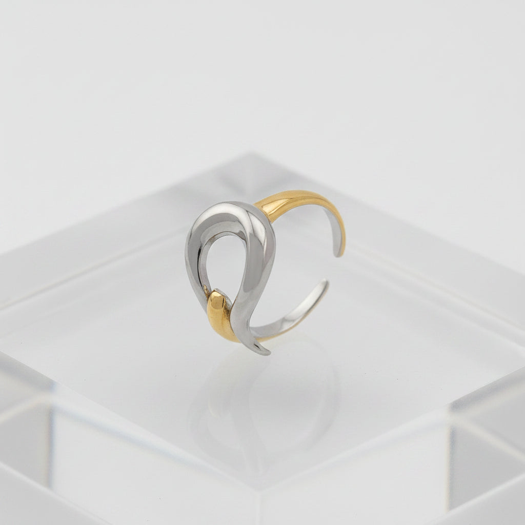 Two-toned silver and gold ring on a gray background