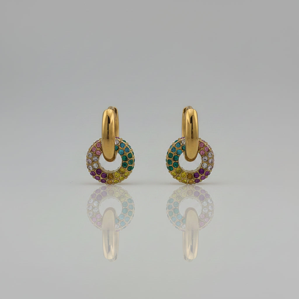 Gold earring with colorful gemstones on a gray card