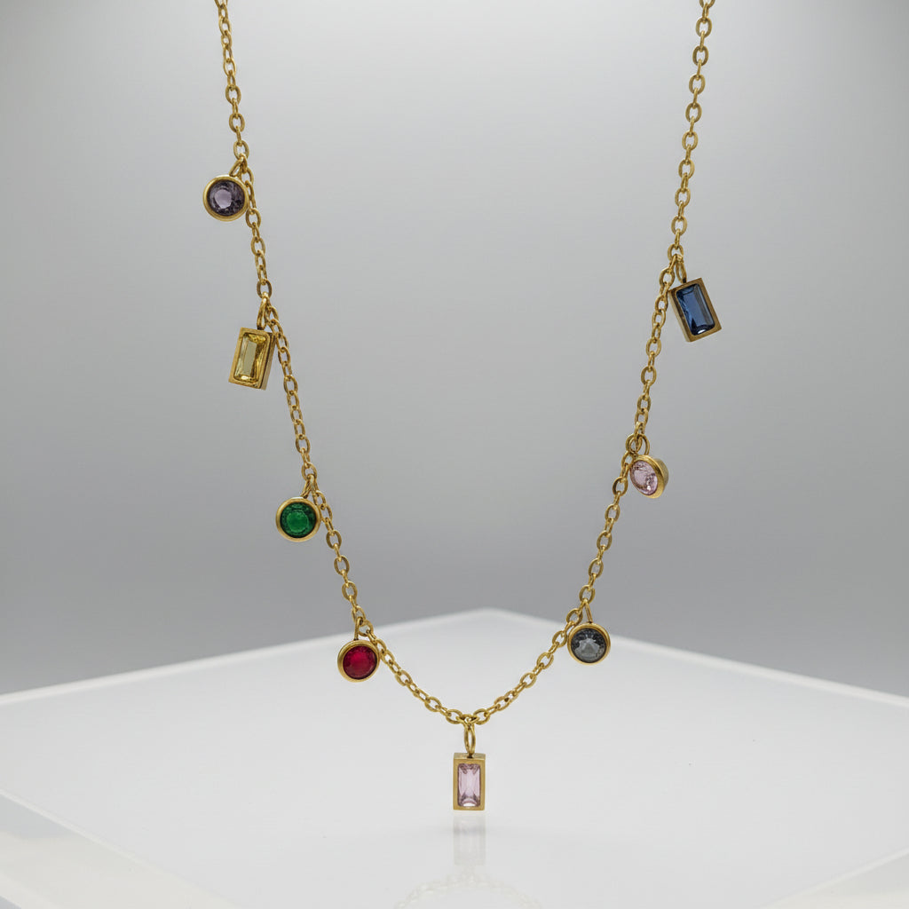 Gold necklace with colorful gemstones on a light gray background
