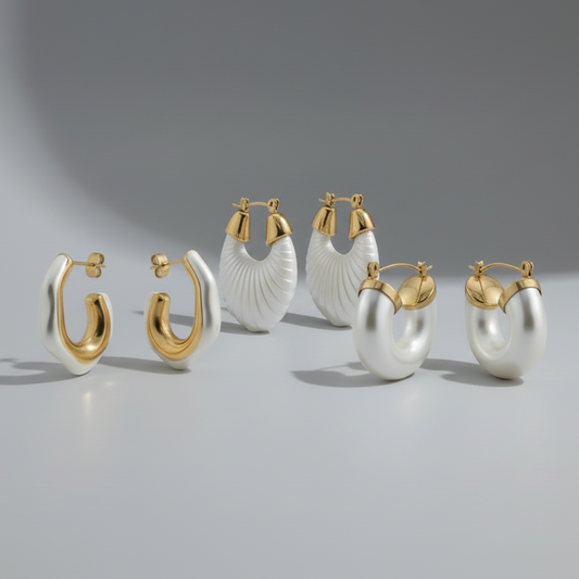 Set of gold and white hoop earrings on a gray background