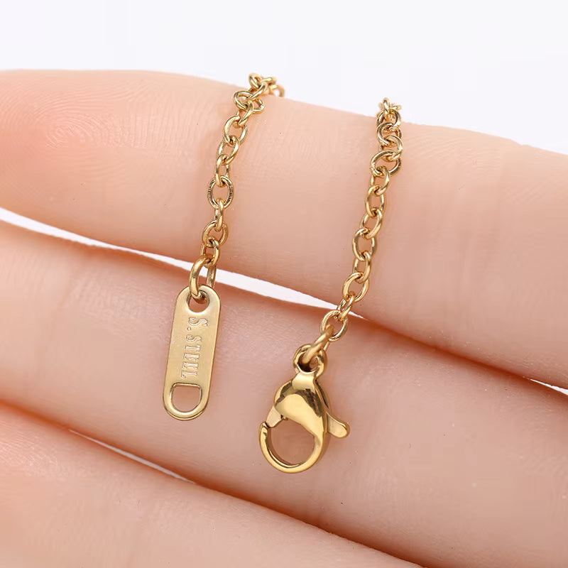 Gold necklace with clasp on a hand against a white background