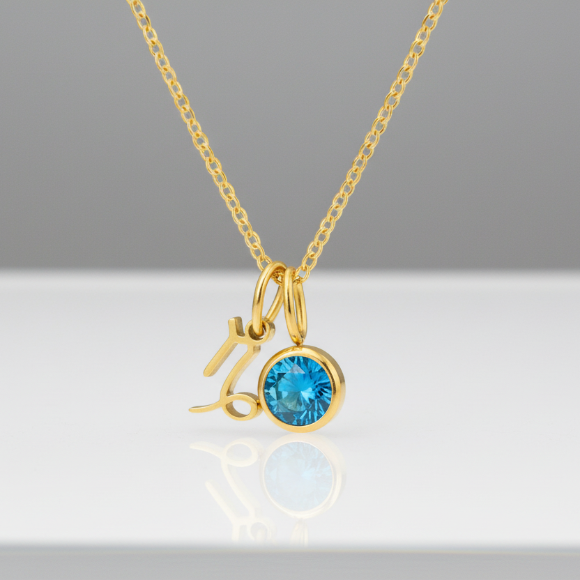 Gold necklace with a blue gemstone pendant on a white background