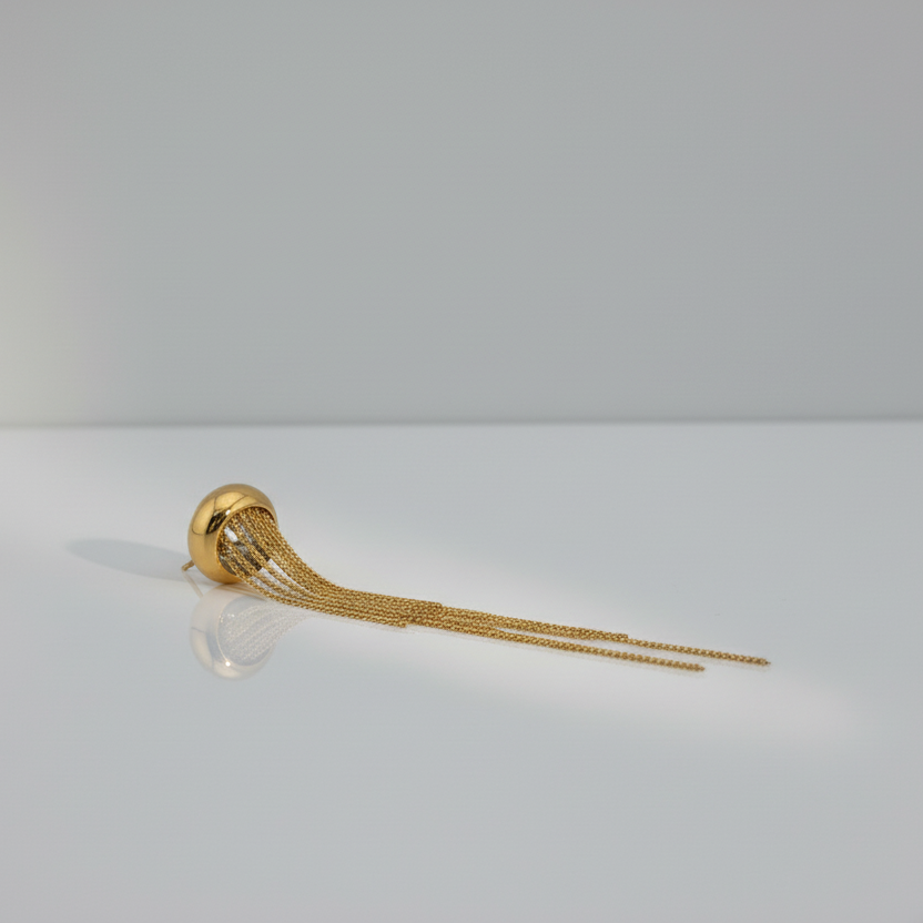 Gold wall-mounted chime on a gray wall