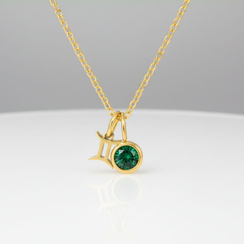 Gold necklace with a green gemstone pendant on a white background