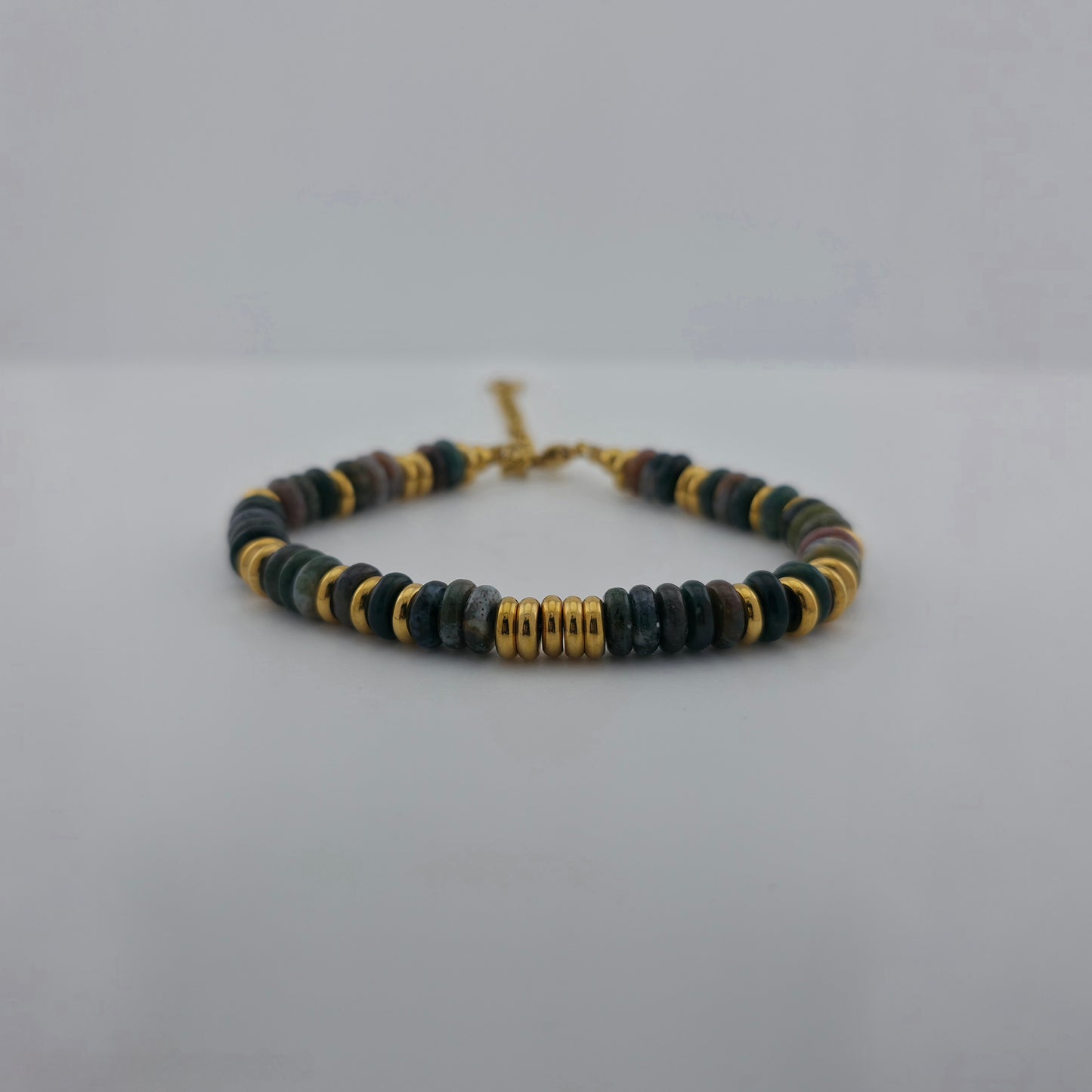 Beaded bracelet with gold accents on a light gray background