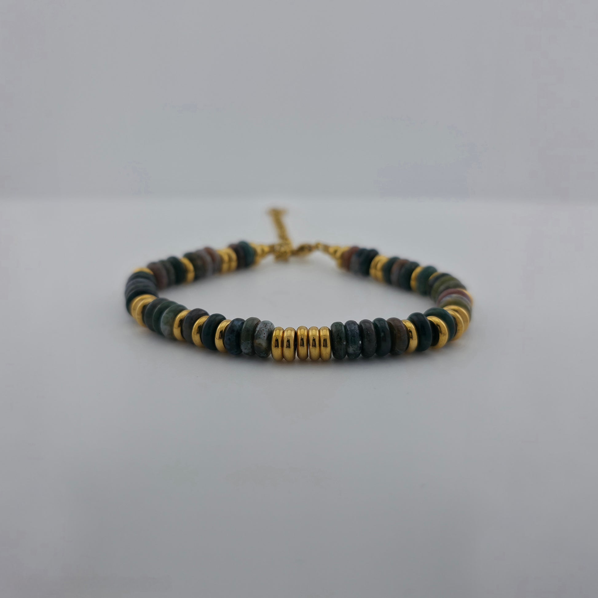 Beaded bracelet with gold accents on a light gray background