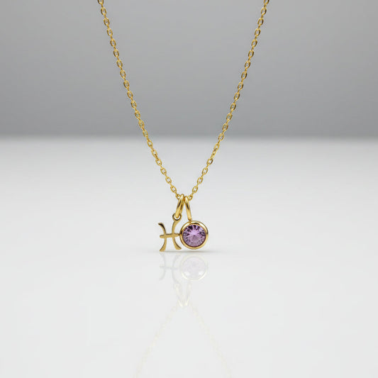 Gold necklace with a starfish and purple gemstone pendant on a light gray background